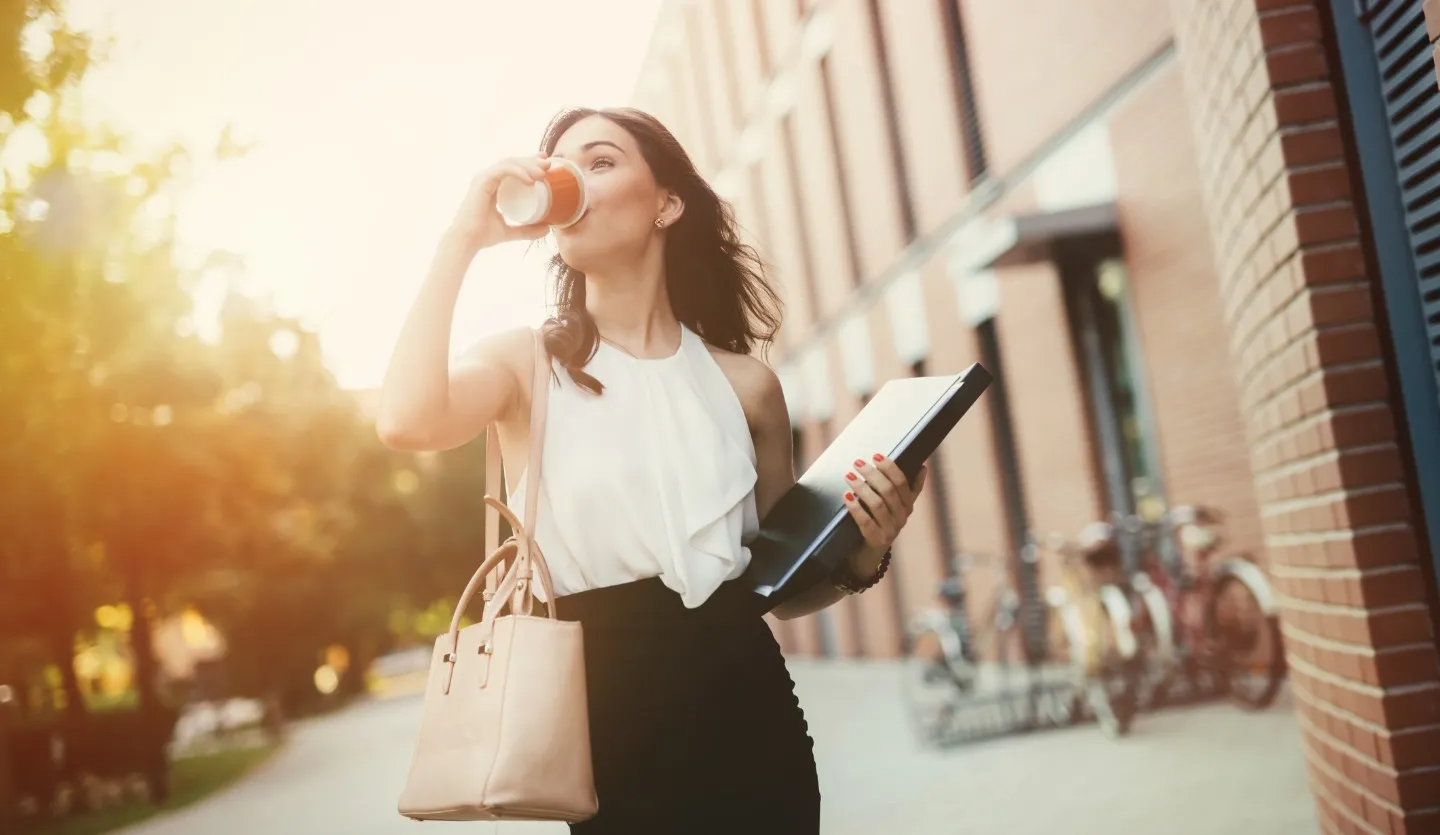 飲み物を飲みながら歩いている女性の画像